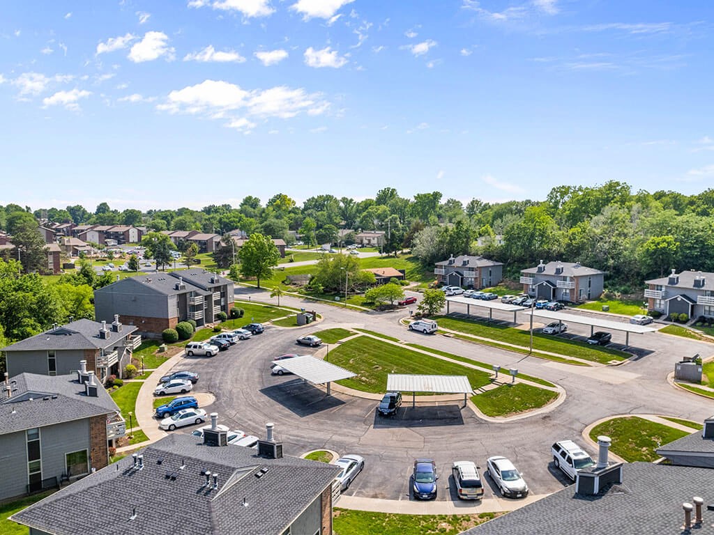 an aerial view of a neighborhood with cars parked on the street