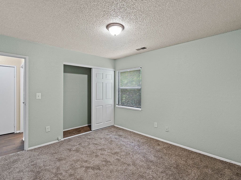apartment bedroom with carpet and closet