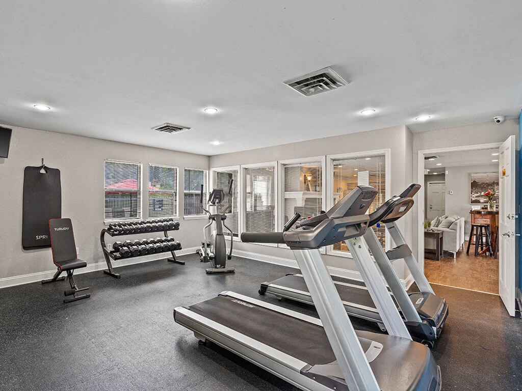 fitness center with treadmills and other exercise equipment