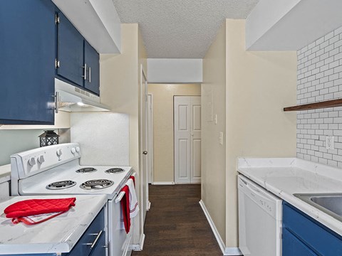 a kitchen with white appliances and blue cabinets