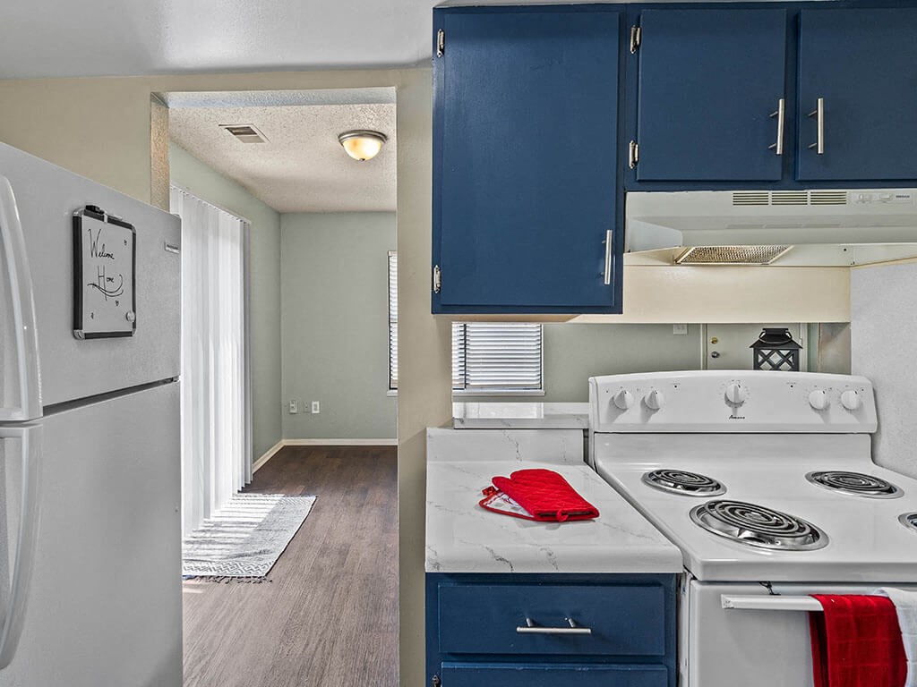 open kitchen with blue cabinets and a white stove and refrigerator