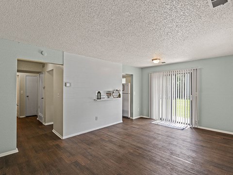 a living room with a wood floor and a sliding glass door