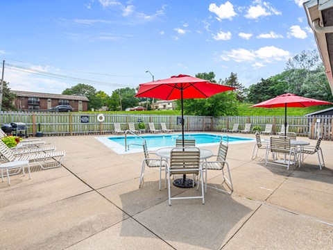 a pool with chairs and umbrellas next to a pool