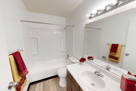 A white bathroom with a toilet, sink, and shower.