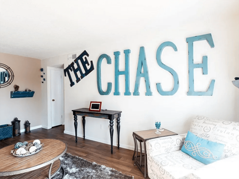 a living room with a couch and a wall spelling out the chase