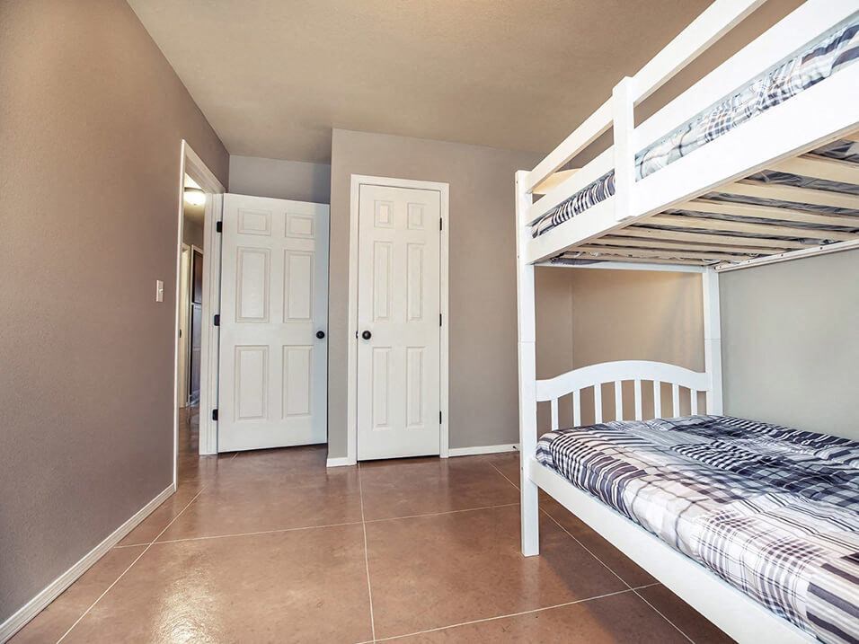 a bedroom with bunk beds and a tiled floor