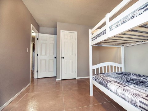 a bedroom with bunk beds and a tiled floor