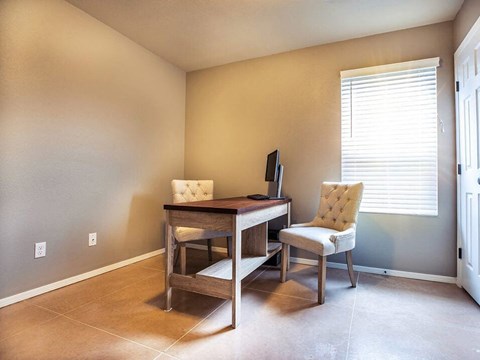 a home office with a desk and two chairs