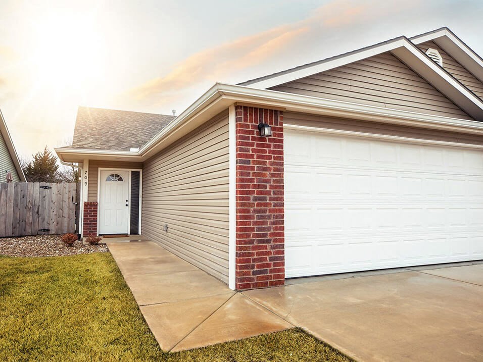 a home with a white garage door and a driveway