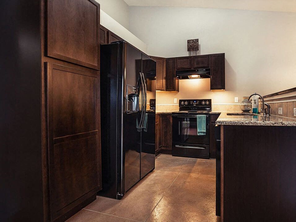 a kitchen with black appliances and wooden cabinets