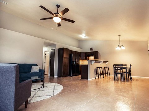 a living room and kitchen with a ceiling fan