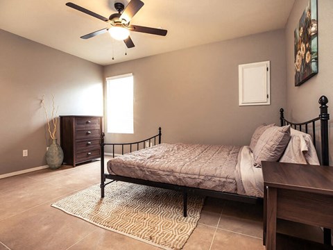 a bedroom with a bed and a ceiling fan
