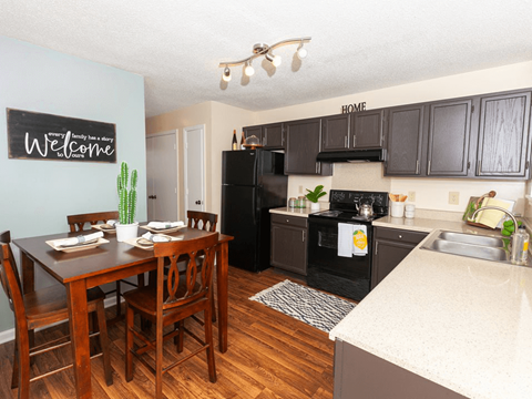 a kitchen with black appliances and a dining room table