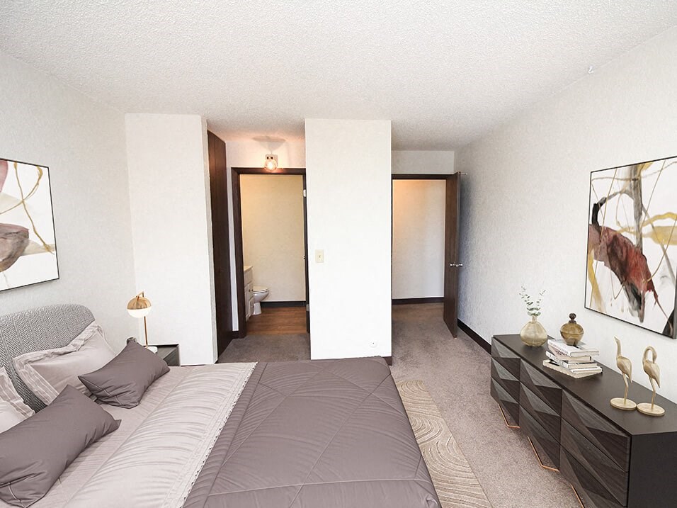 apartment bedroom with a large bed and a bathroom