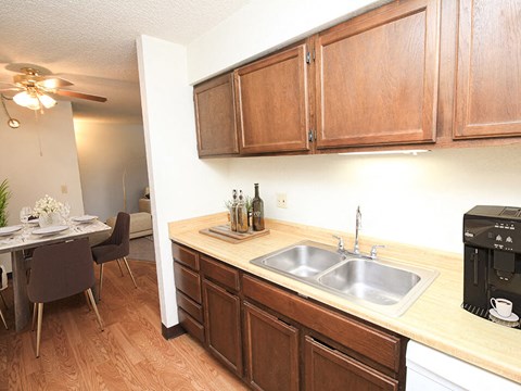 a kitchen with wooden cabinets and a stainless steel sink