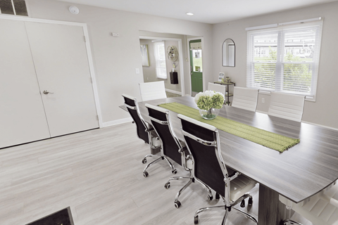 A conference room with a long table and chairs.