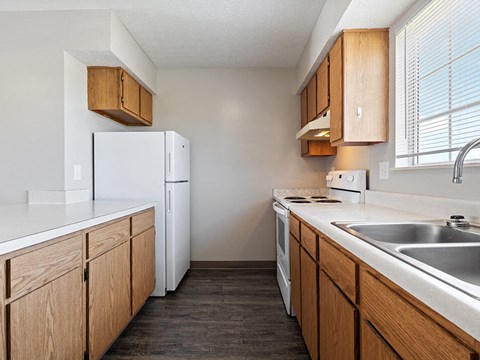 A kitchen with wooden cabinets and white appliances.