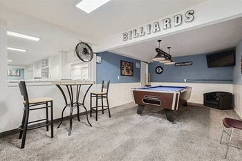 a game room with a pool table and a bar