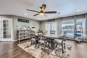 a dining room with a table and chairs and a ceiling fan
