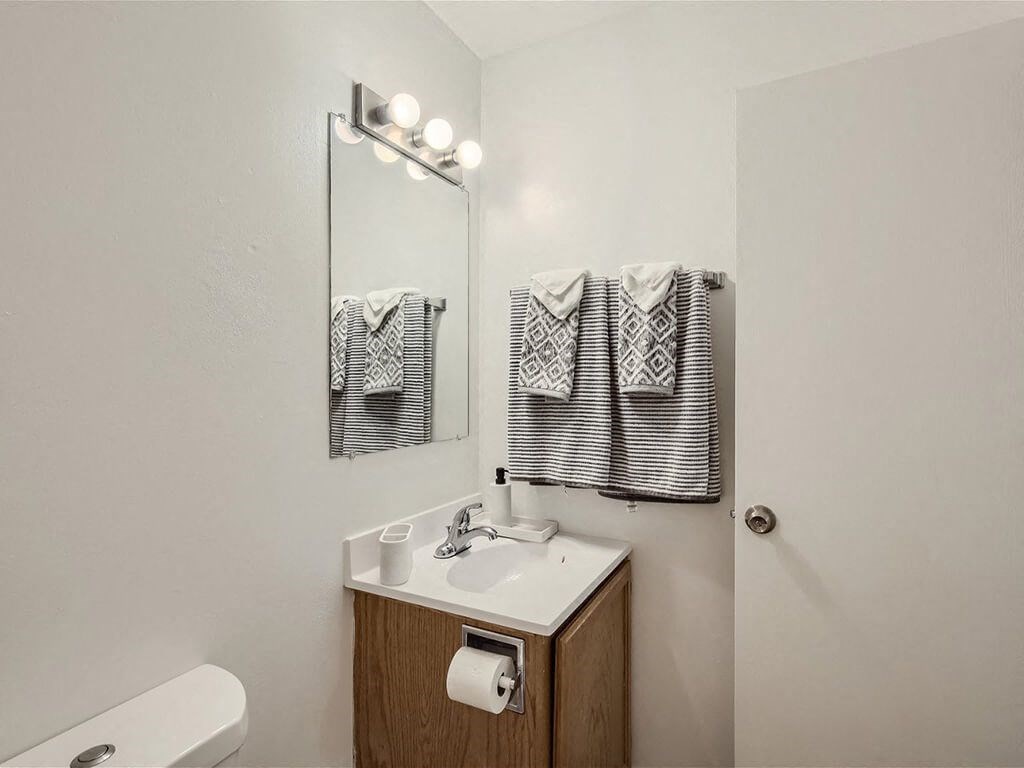 apartment bathroom with a mirror and a sink