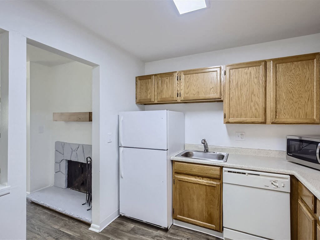 a kitchen with white appliances and wooden cabinets