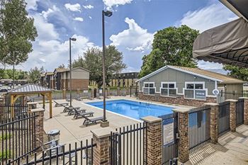 a pool with chairs and a fence around it