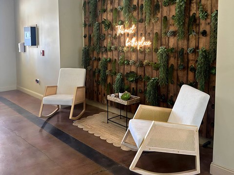 a seating area with two chairs and a sign on the wall