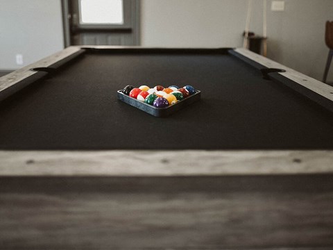 a pool table with a bowl of balls on it
