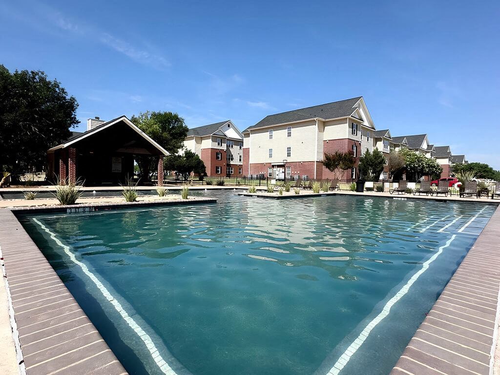 a large swimming pool with houses in the background