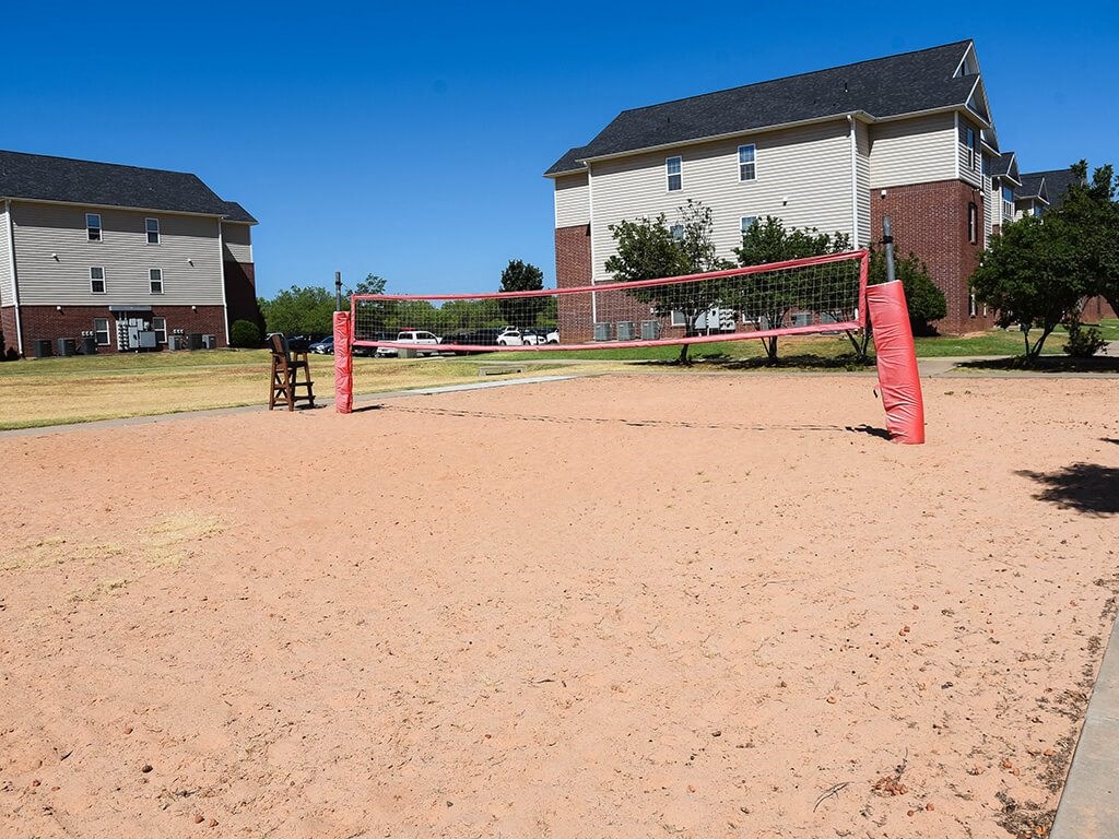 a sand volleyball court in front of a house