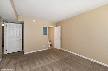 an empty living room with a door to a bathroom