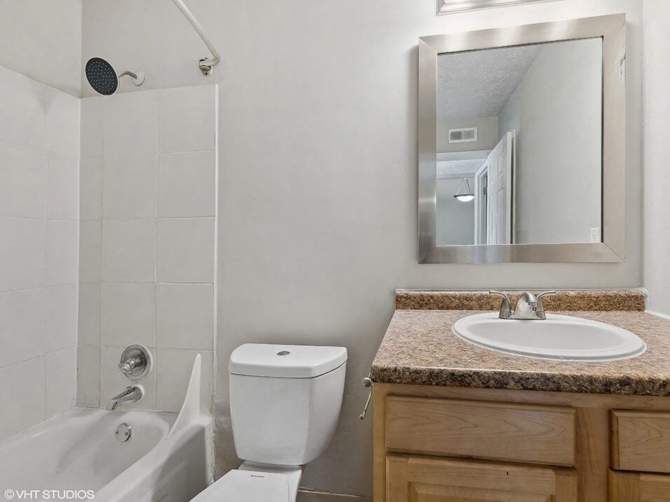 a white bathroom with a sink, toilet, and a tub
