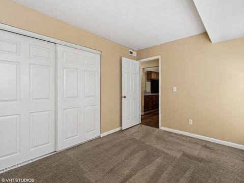 a bedroom with two closets and a door to the bathroom