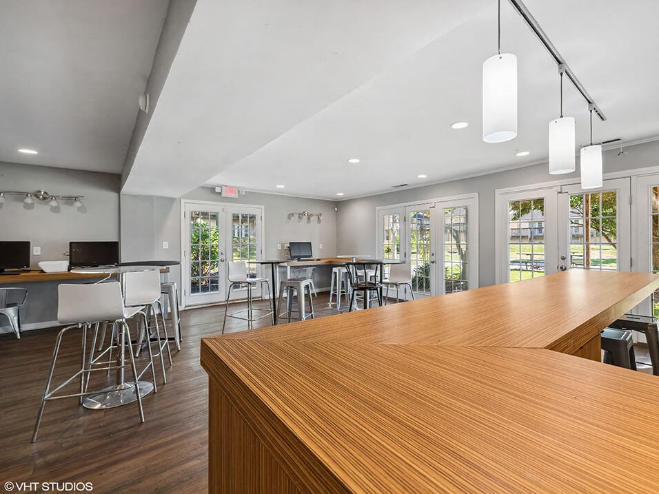 a large bar with chairs and tables in a room with windows
