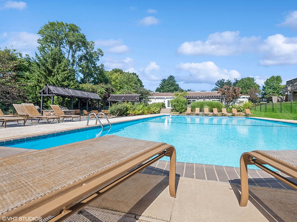 a swimming pool with chairs around it