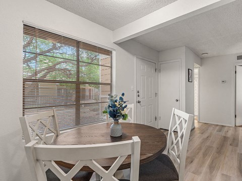 a dining room with a table and chairs and a window