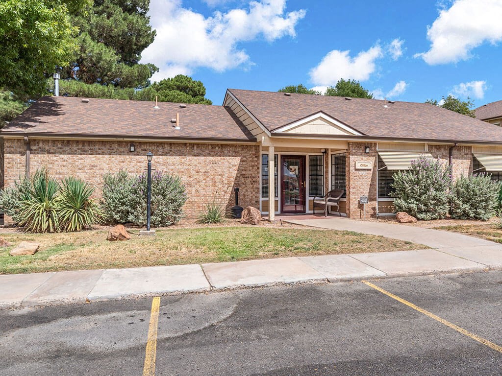 a small brick house with a sidewalk in front of it