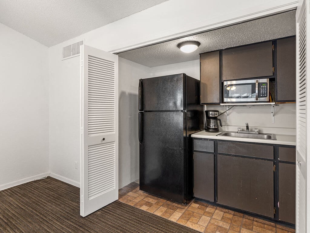 a kitchen with a refrigerator microwave and sink