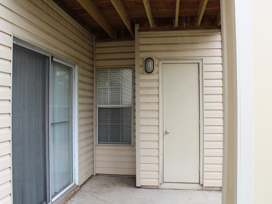a front porch with a white door and a window