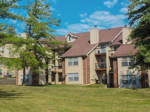 A large apartment complex with a grassy area in front.