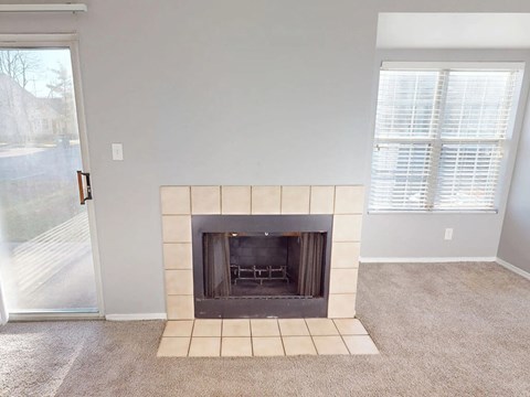 A living room with a fireplace and a sliding glass door.