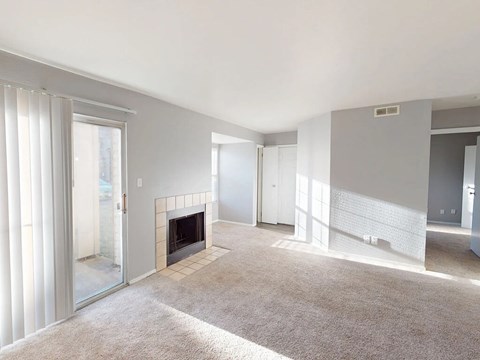 A living room with a fireplace and a carpet.