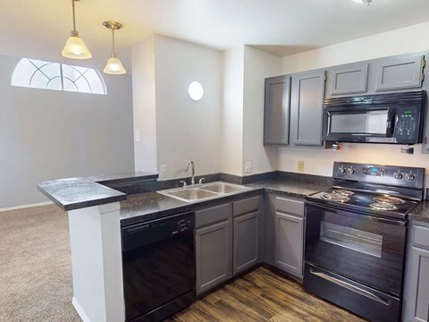 A kitchen with a black stove top oven and microwave.