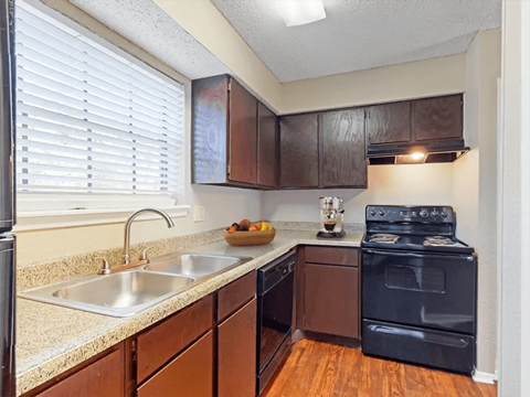 a kitchen with a sink and a stove and a window