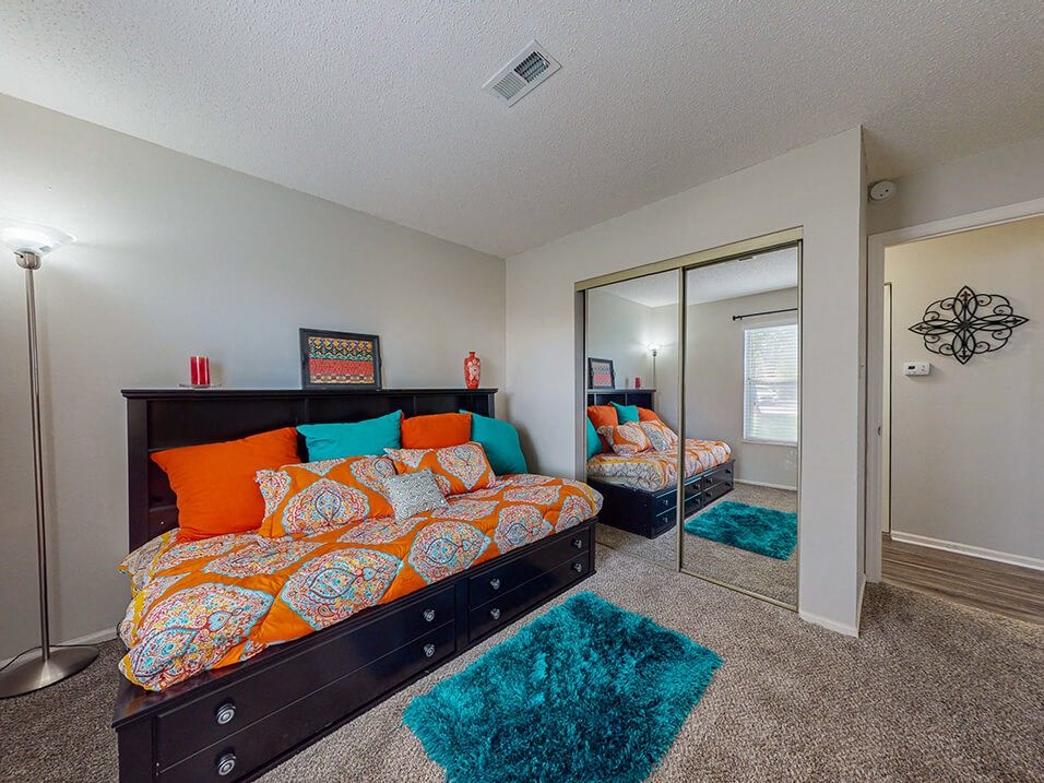 a bedroom with a bed and a mirror