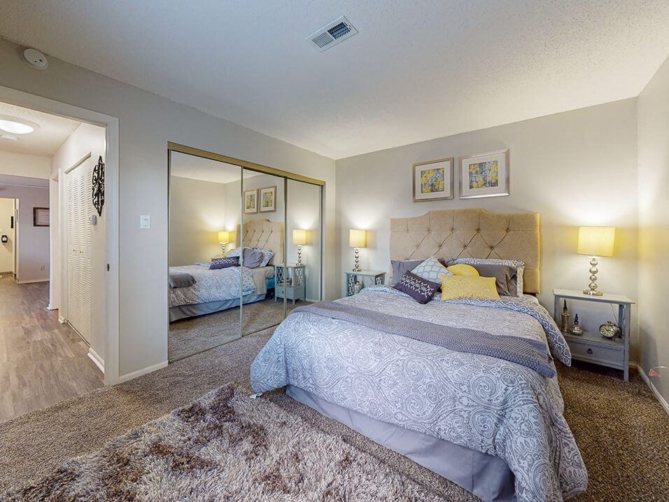 apartment bedroom with a large bed and a large closet