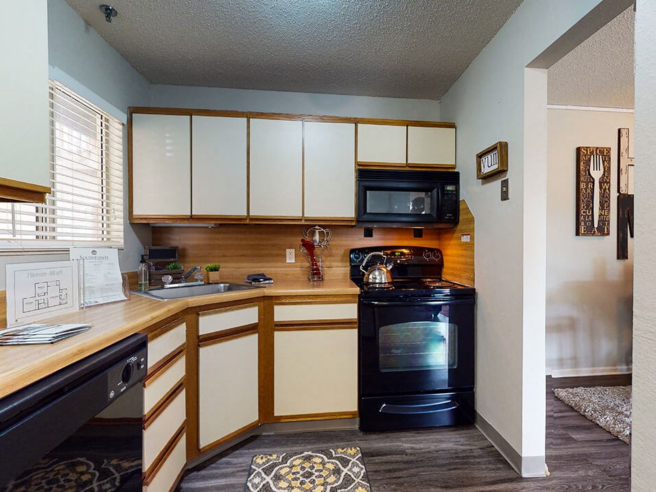 a kitchen with white cabinets and black appliances