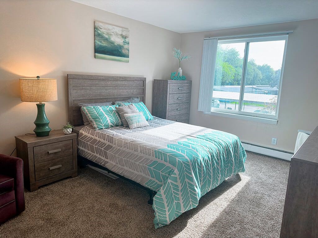 a bedroom with a bed and a large window