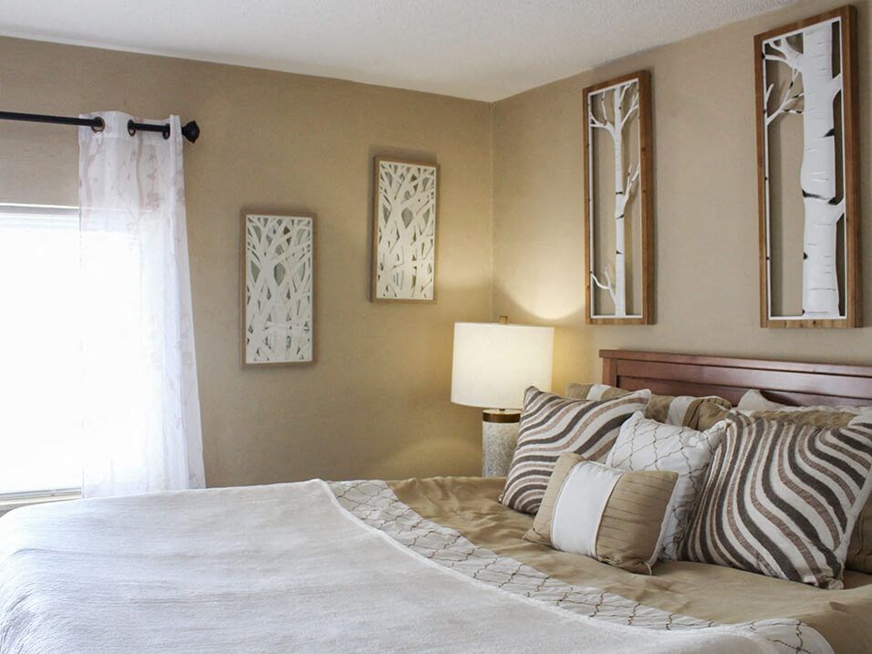 a bedroom with a large bed and big mirrors