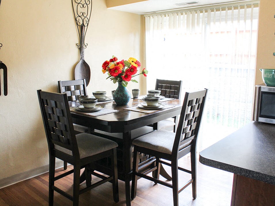 a dining room table with a vase of flowers on top of it